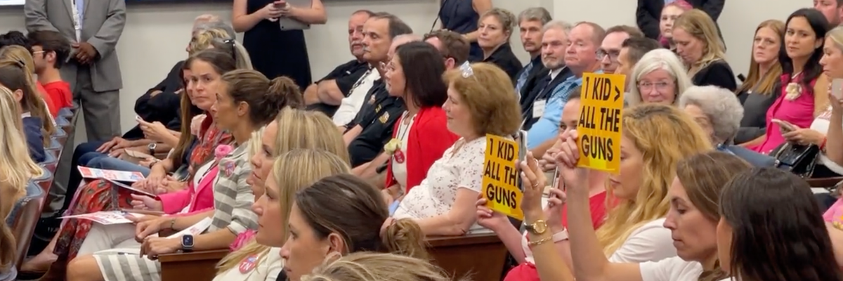 Two pro-gun control protesters hold up signs