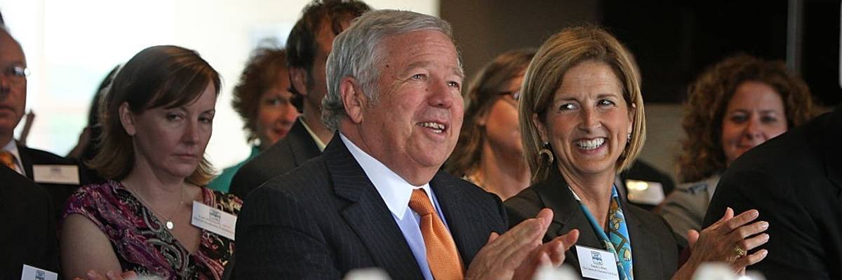 Two wealthy donors clap at a gala.