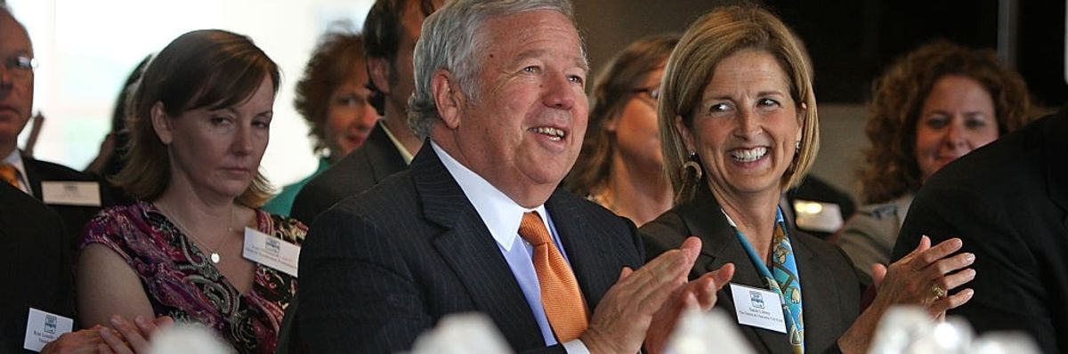 Two wealthy donors clap at a gala.