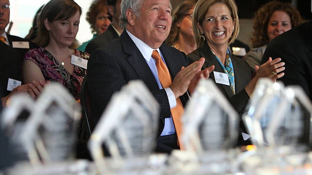 Two wealthy donors clap at a gala.
