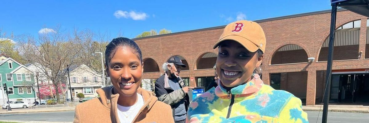 Two women holding signs that say "Fair Share for Massachusetts"