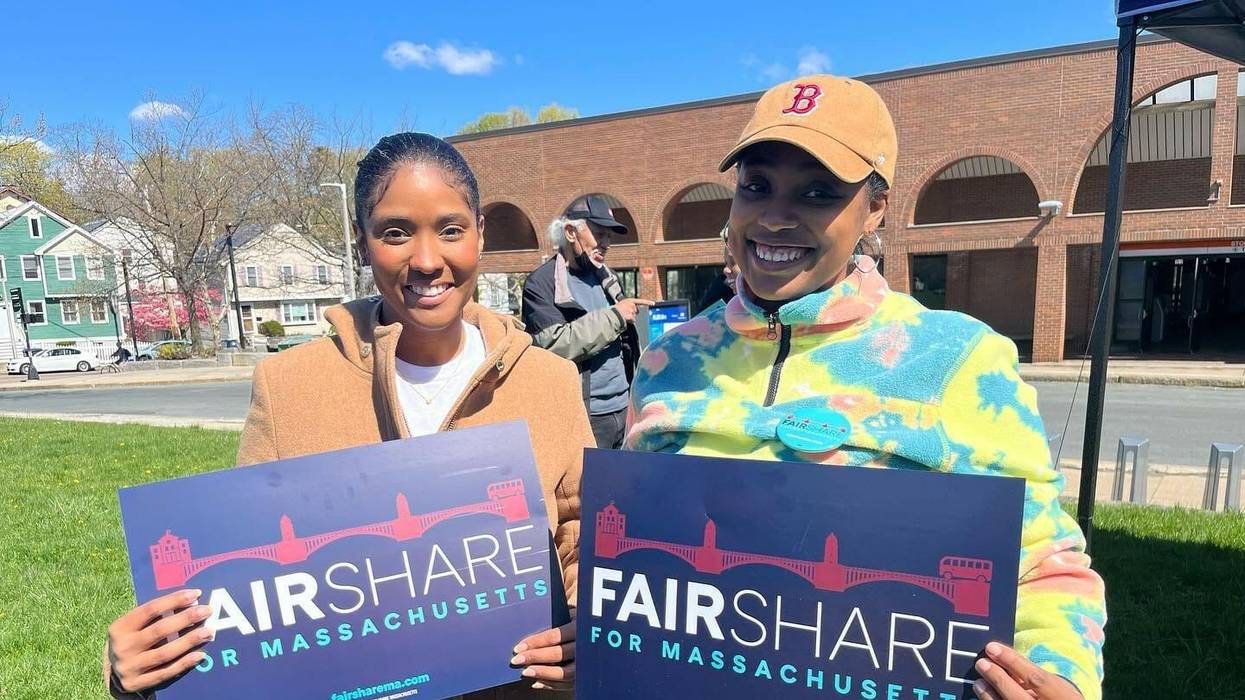 Two women holding signs that say "Fair Share for Massachusetts"