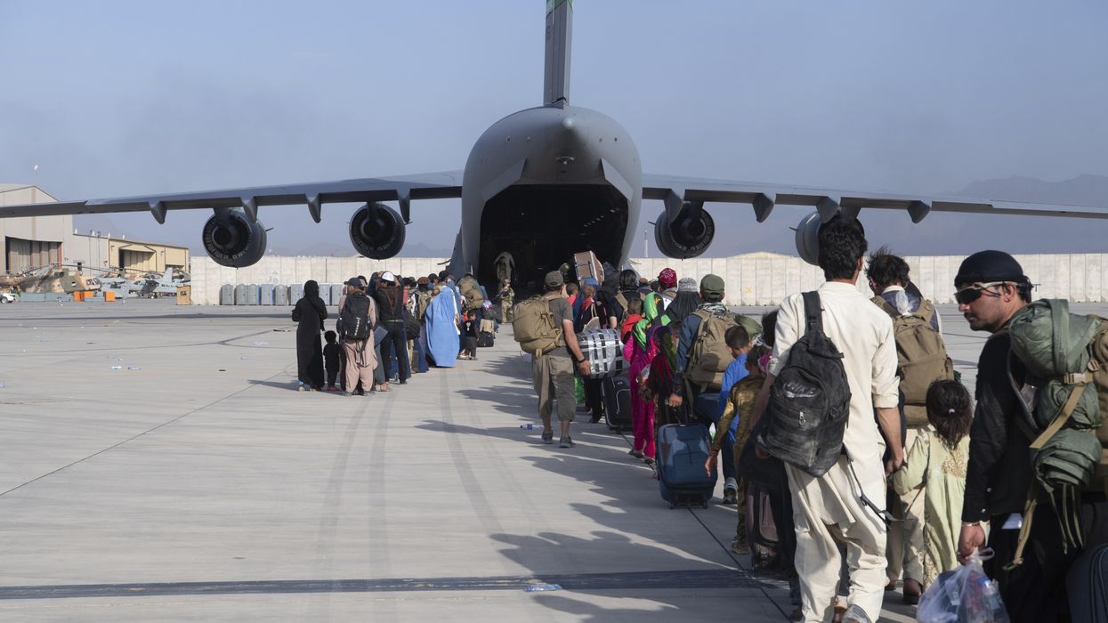 U.S. Air Force l load passengers aboard a U.S. Air Force C-17 Globemaster III in support of the Afghanistan evacuation at Hamid Karzai International Airport