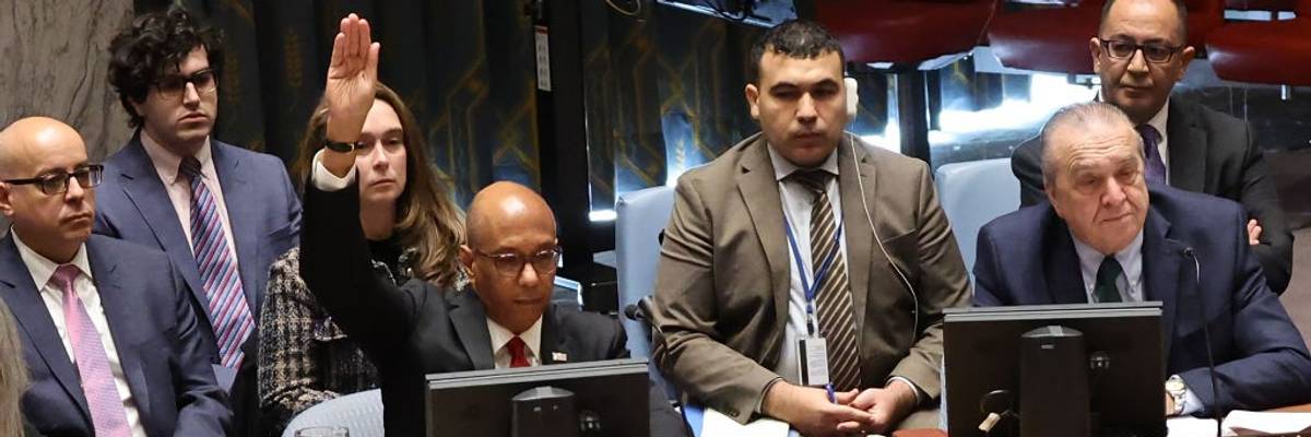 U.S. Ambassador Robert Wood raises his hands to veto a draft resolution