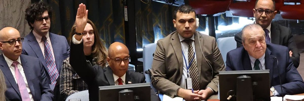 U.S. Ambassador Robert Wood raises his hands to veto a draft resolution