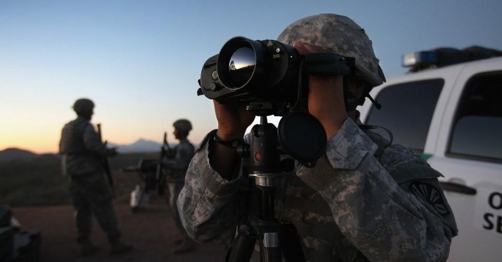 U.S. Army National Guardsman Sgt. Oscar Escobar scans the U.S.-Mexico border at dusk on June 22, 2011 in Nogales, Arizona. (Photo by John Moore/Getty Images)