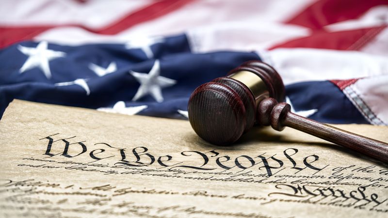 U.S. flag, gavel, and Constitution.