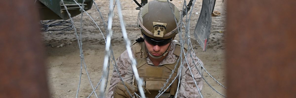 U.S. Marine installing concertina wire at border wall.