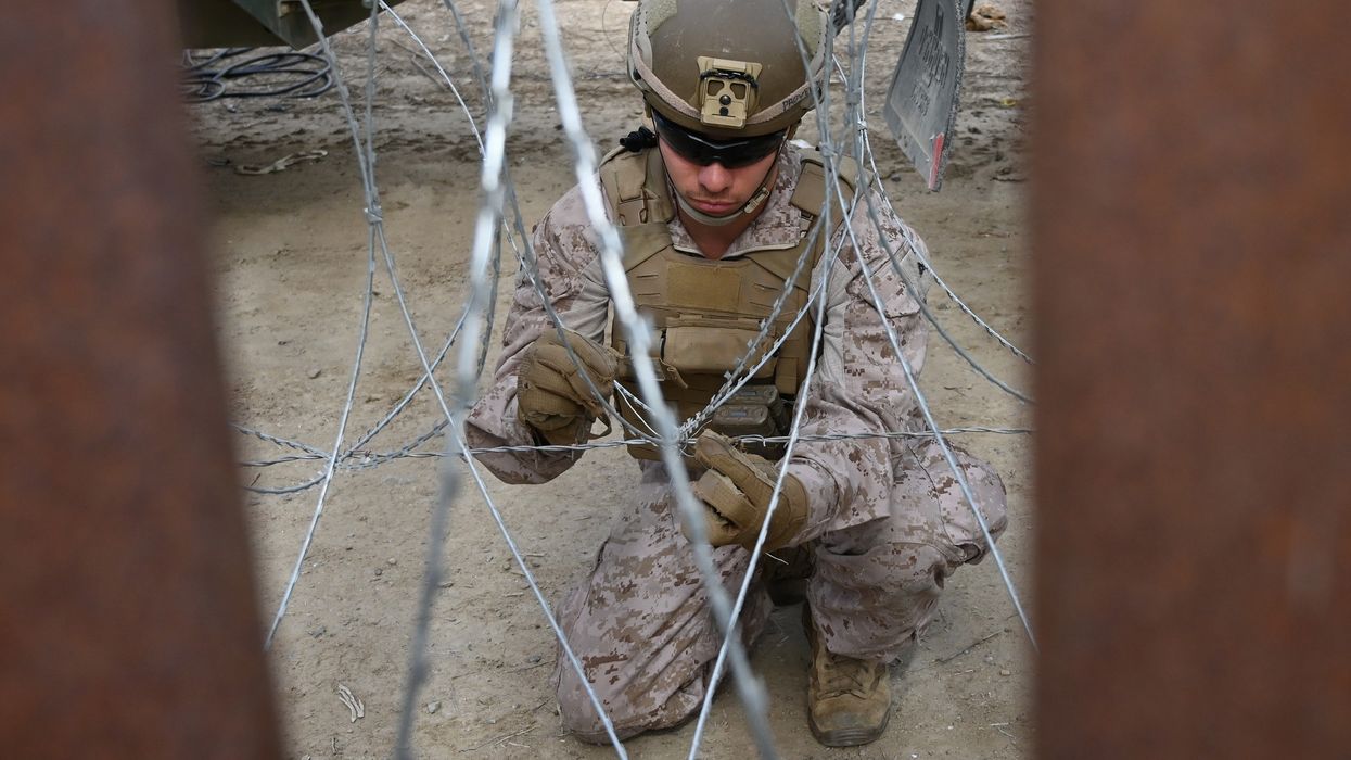 U.S. Marine installing concertina wire at border wall.