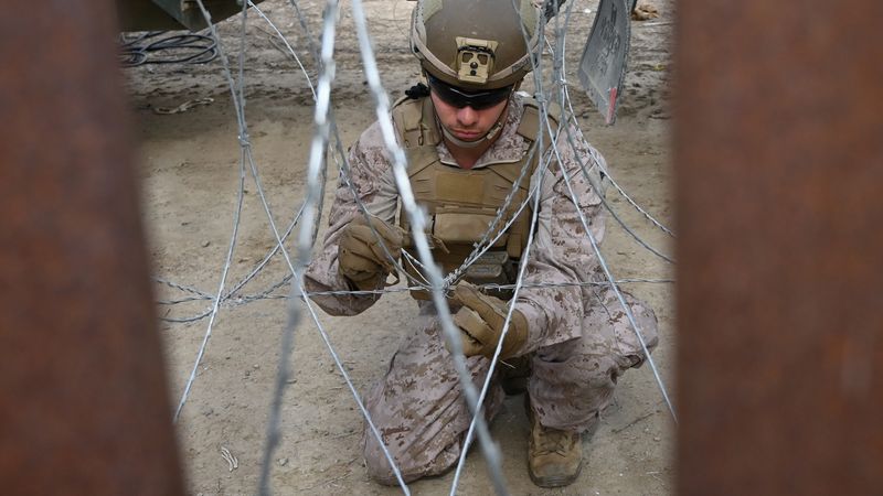 U.S. Marine installing concertina wire at border wall.