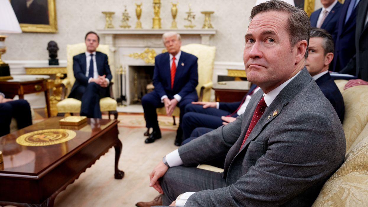 U.S. President Donald Trump, accompanied by U.S. National Security Adviser Michael Waltz (R), takes a question from a reporter