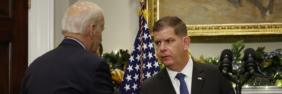 U.S. President Joe Biden (L) shakes hands with Labor Secretary Marty Walsh