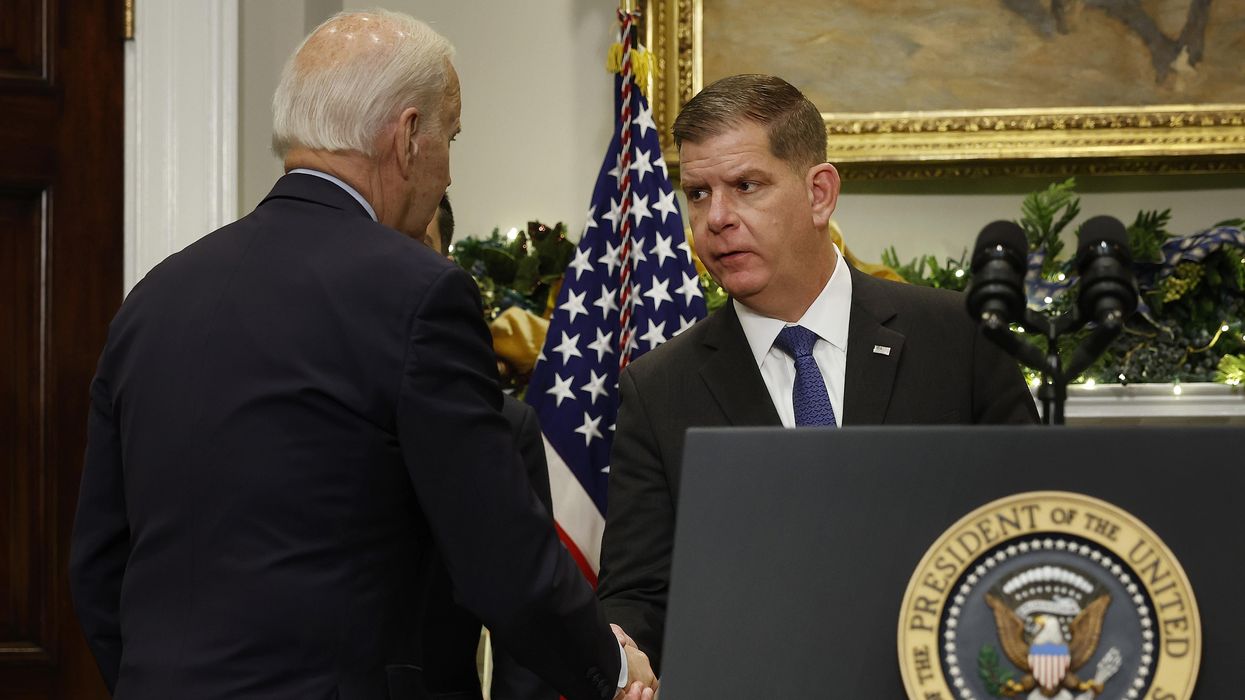 U.S. President Joe Biden (L) shakes hands with Labor Secretary Marty Walsh