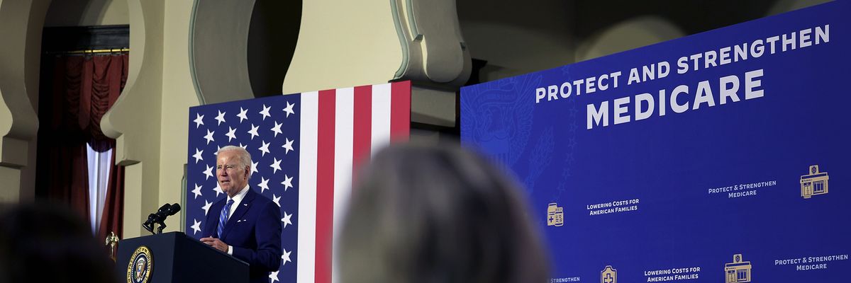 U.S. President Joe Biden speaks next to a sign saying, "Protect and strengthen Medicare."