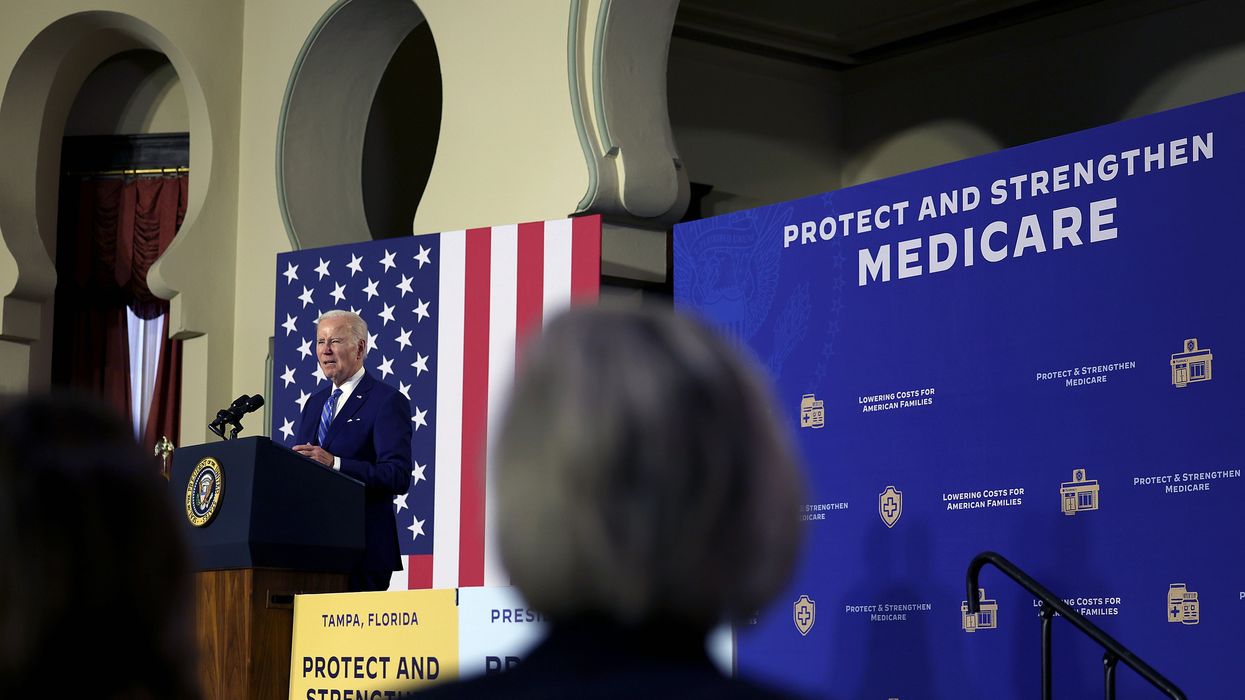 U.S. President Joe Biden speaks next to a sign saying, "Protect and strengthen Medicare."