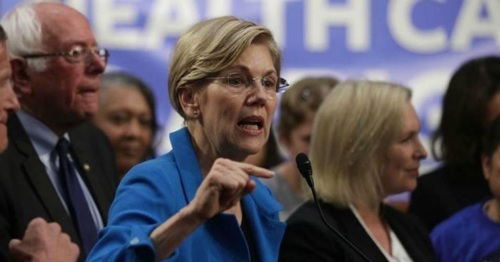 U.S. Sen. Elizabeth Warren (D-Mass.) speaks on health care as Sen. Bernie Sanders (I-Vt.) listens during an event September 13, 2017 on Capitol Hill in Washington, D.C. (Photo by Alex Wong/Getty Images)
