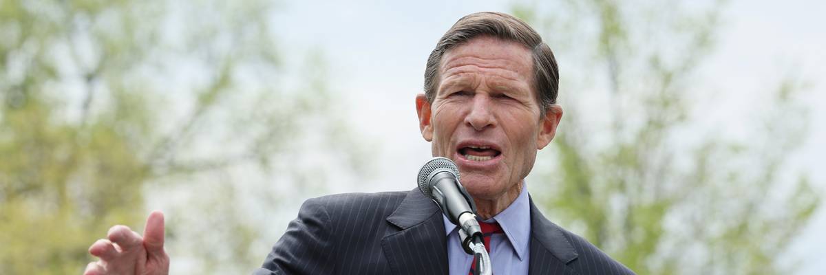 U.S. Senator Richard Blumenthal stands at a podium wearing a suit.