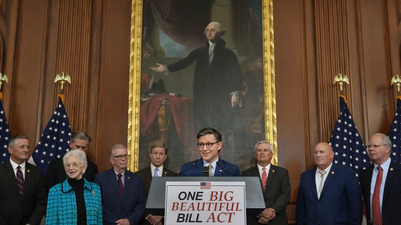 U.S. Speaker of the House Mike Johnson stands above podium reading, "One Big Beautiful Bill Act."
