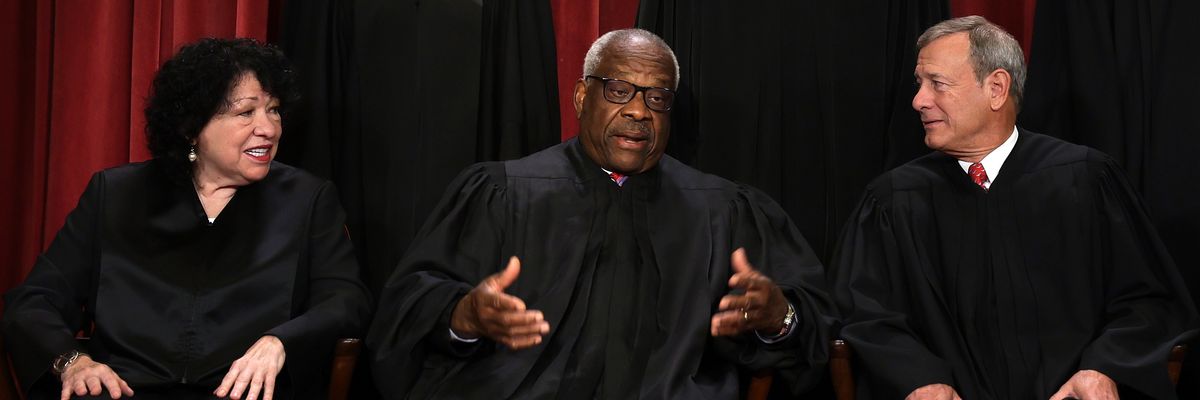 U.S. Supreme Court Justice Clarence Thomas speaks with fellow justices