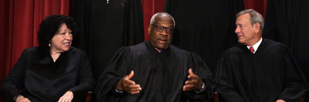 U.S. Supreme Court Justice Clarence Thomas speaks with fellow justices