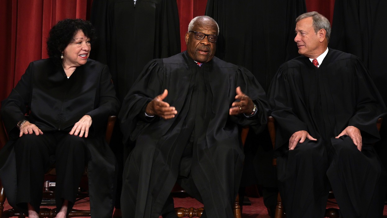U.S. Supreme Court Justice Clarence Thomas speaks with fellow justices