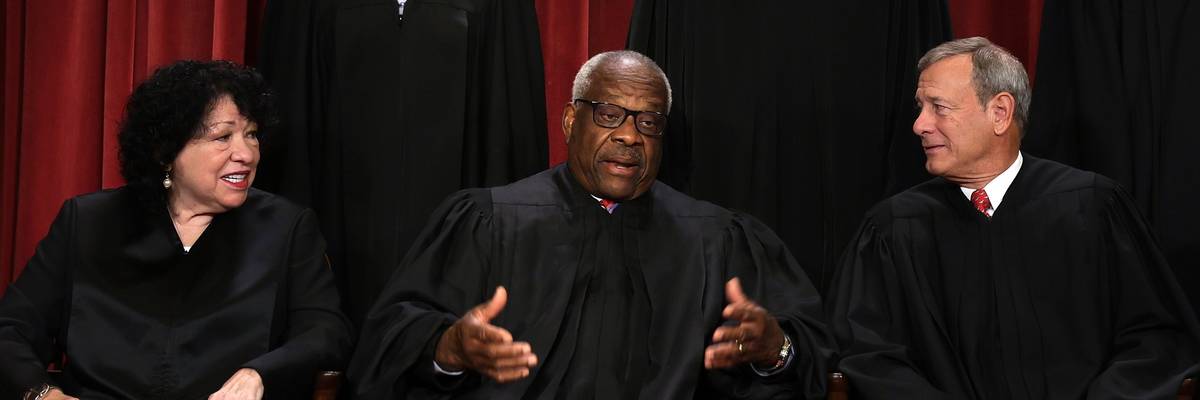 U.S. Supreme Court Justice Clarence Thomas speaks with fellow justices