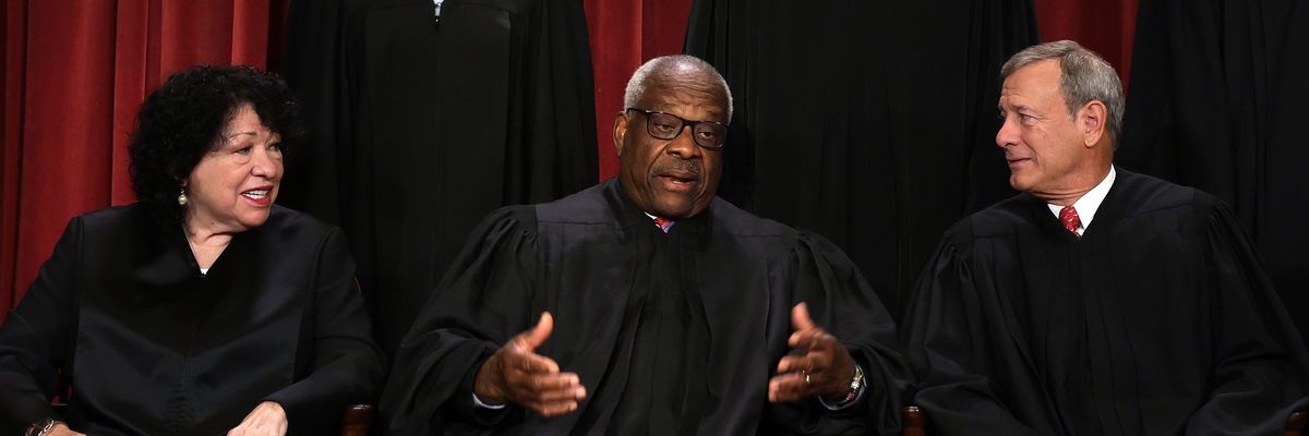 U.S. Supreme Court Justice Clarence Thomas speaks with fellow justices