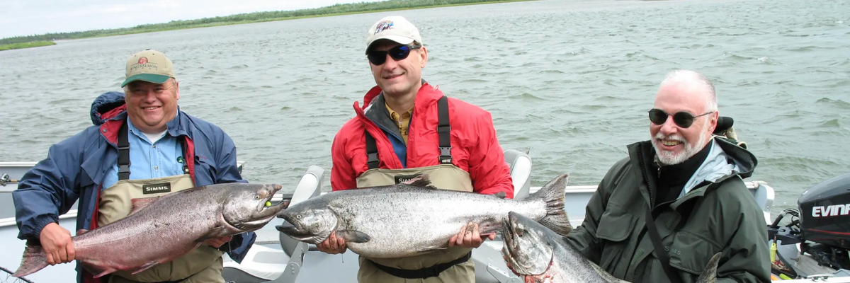 U.S. Supreme Court Justice Samuel Alito, center, and hedge fund billionaire Paul Singer, right, hold king salmon.
