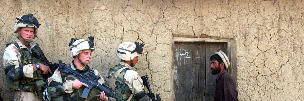 U.S. troops prepare to raid a family's home in southeastern Afghanistan on November 7, 2002.
