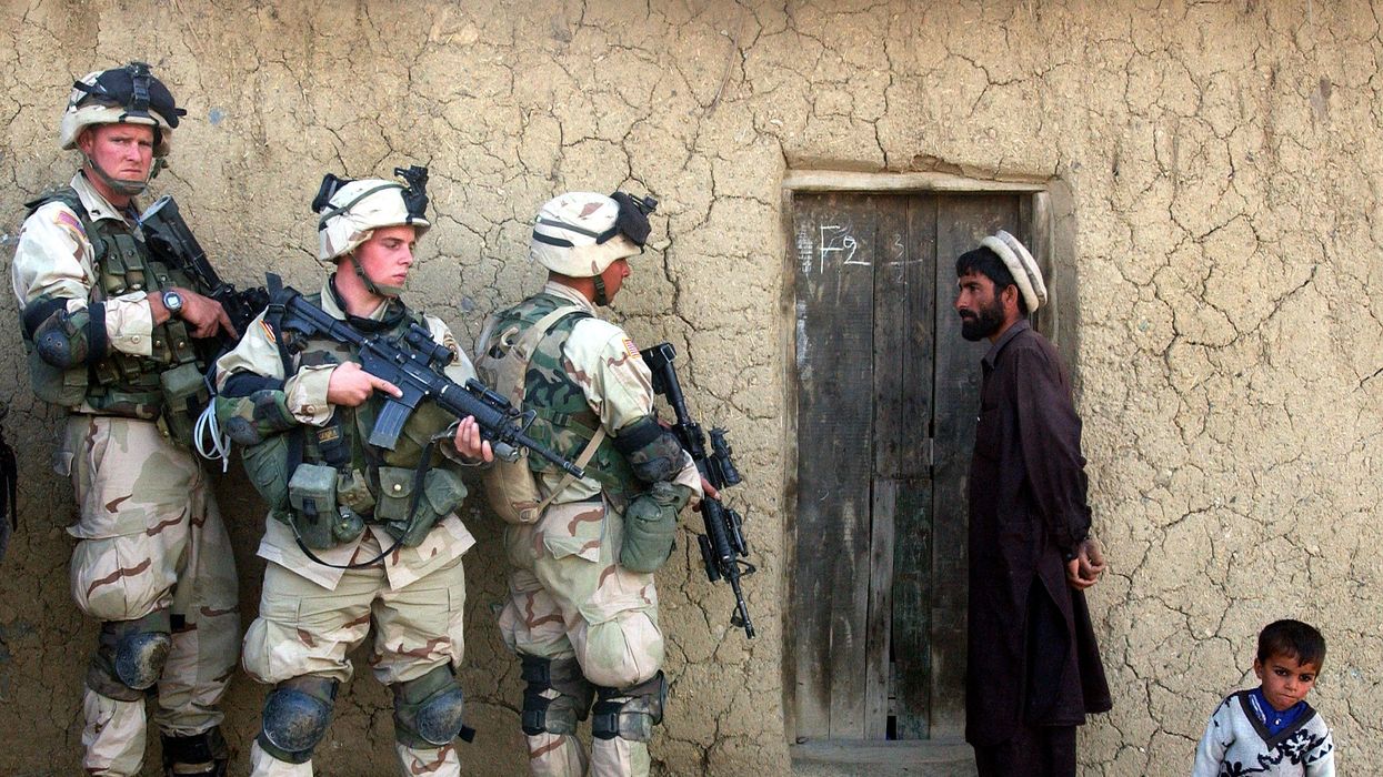 U.S. troops prepare to raid a family's home in southeastern Afghanistan on November 7, 2002.