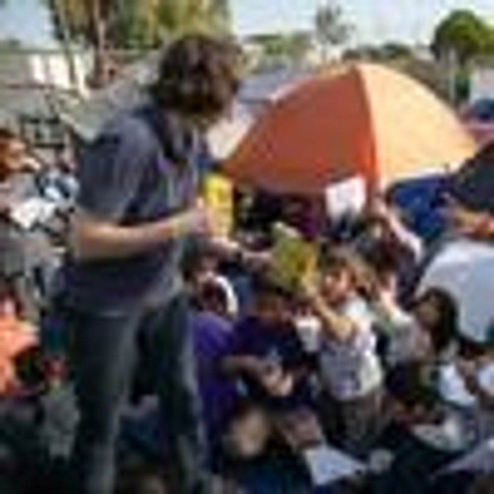 U.S. volunteer Mary Keenan of Brownsville, Texas hands out markers on December 8, 2019 during a class for immigrant children at a refugee camp near the Gateway International Bridge in the border town of Matamoros, Mexico
