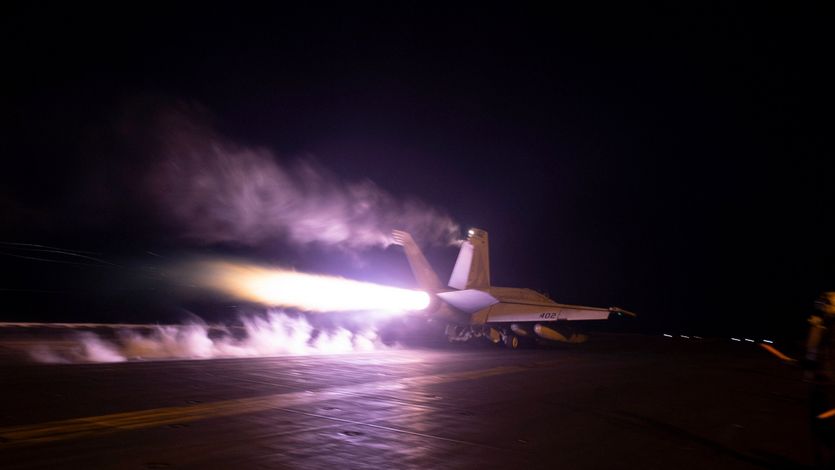 U.S. warplane takes off from aircraft carrier at night
