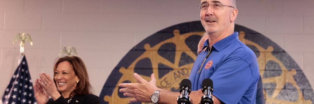 UAW president Shawn Fain gestures toward U.S. Vice President Kamala Harris