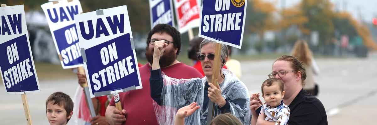 UAW workers and their kids picket outside Ford's assembly plant in Wayne, Michigan.