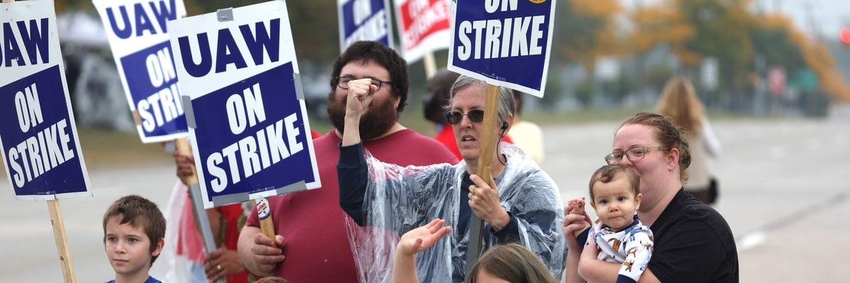 UAW workers and their kids picket outside Ford's assembly plant in Wayne, Michigan.