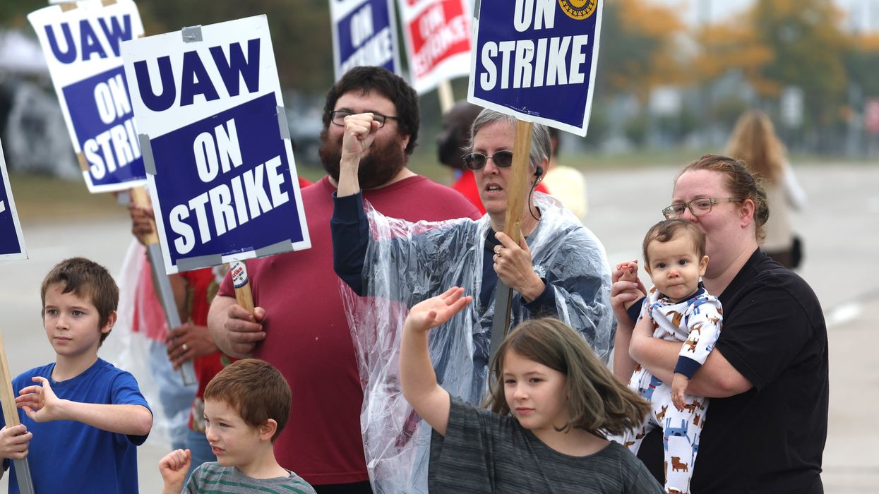 UAW workers and their kids picket outside Ford's assembly plant in Wayne, Michigan.