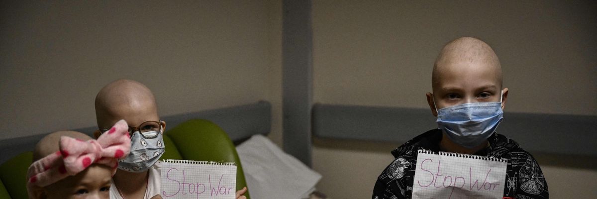 Ukrainian children holding signs that say "Stop War"