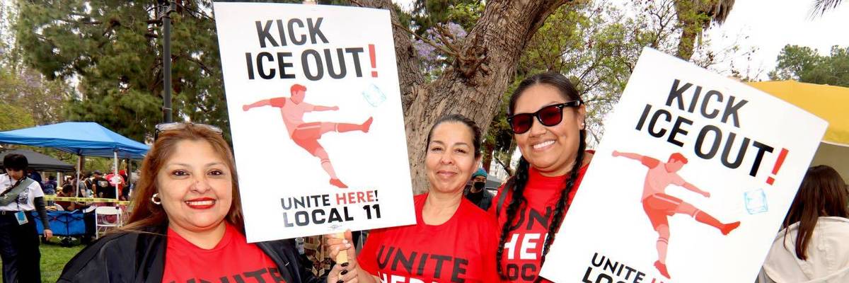 Union members protest ICE presence at the FIFA World Cup. Their signs say, "Kick ICE Out!"