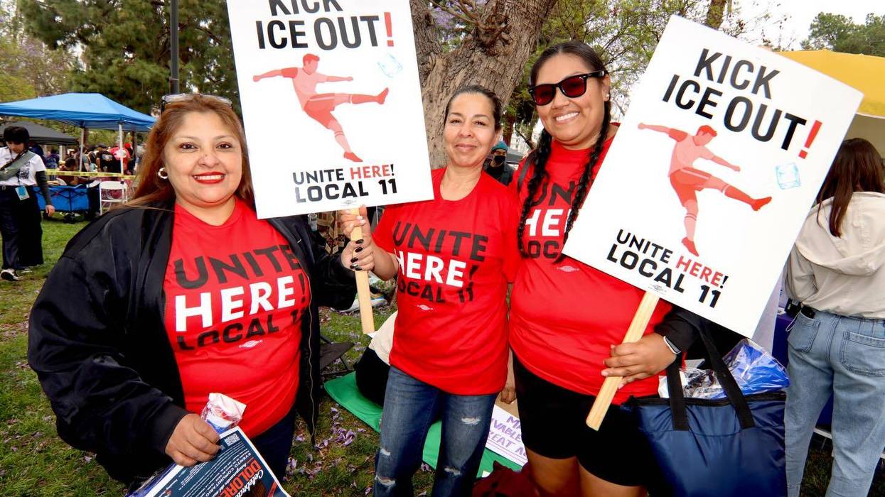 Union members protest ICE presence at the FIFA World Cup. Their signs say, "Kick ICE Out!"