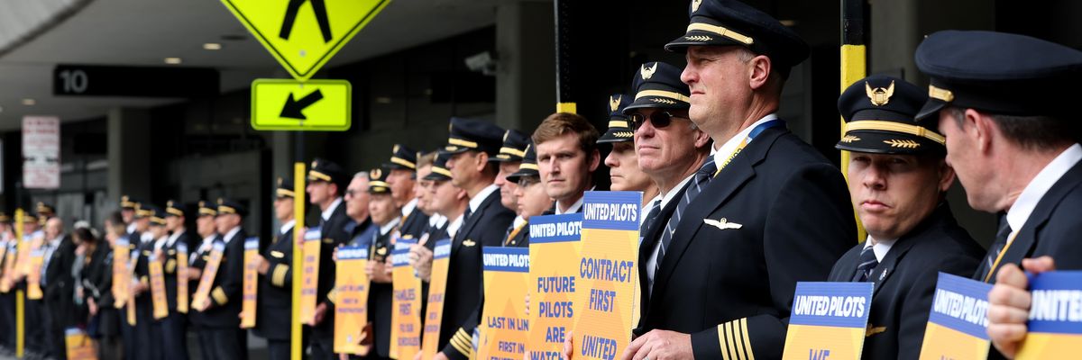 United Airlines pilots hold signs in front of the company's terminal at San Francisco International Airport on May 12, 2023.