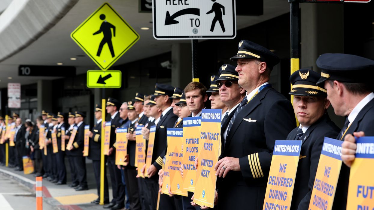 United Airlines pilots hold signs in front of the company's terminal at San Francisco International Airport on May 12, 2023.