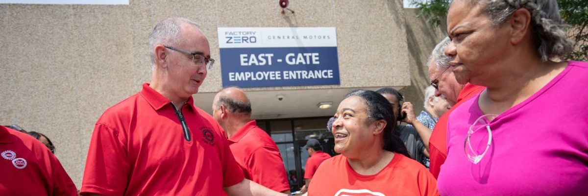 United Auto Workers president Shawn Fain greets a woman holding a 'United for a strong contract" sign.