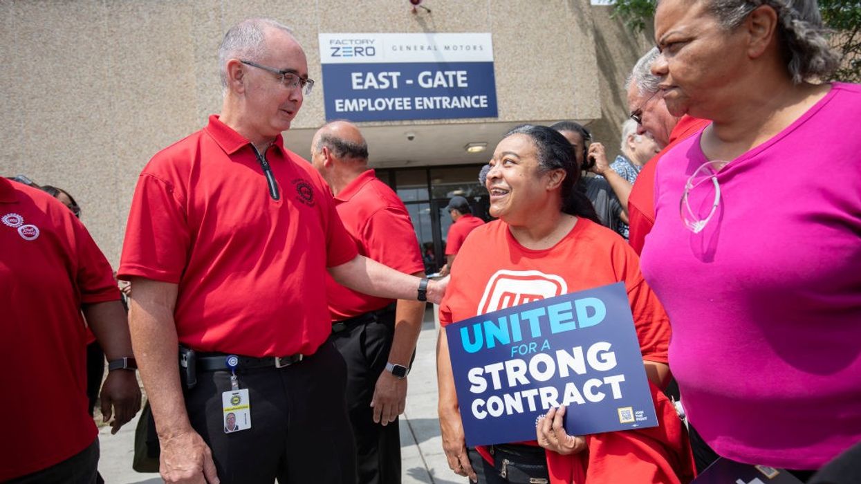 United Auto Workers president Shawn Fain greets a woman holding a 'United for a strong contract" sign.