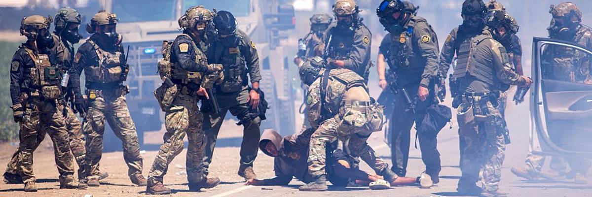 US CBP officials arrest a person on the ground.