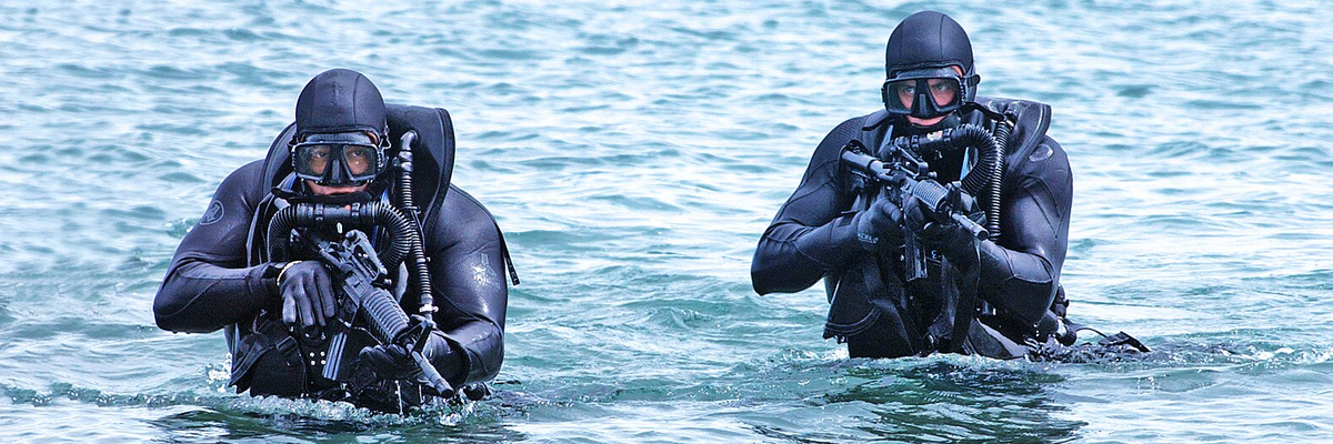 US Navy SEALs in the water with guns