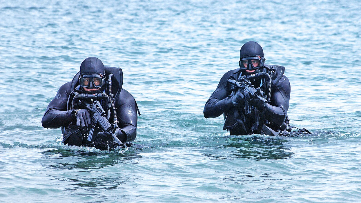 US Navy SEALs in the water with guns