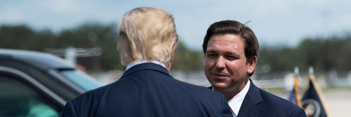 US President Donald Trump is greeted by Florida Governor Ron DeSantis