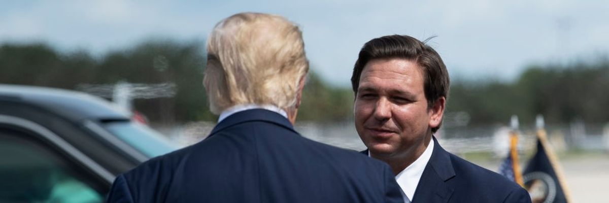 US President Donald Trump is greeted by Florida Governor Ron DeSantis 