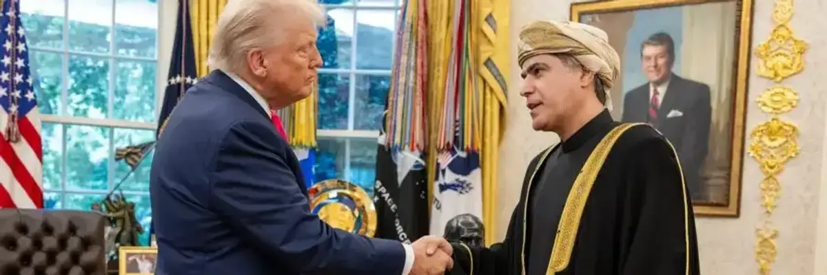 US President Donald Trump shakes hands with Omani Ambassador Talal Alrahbi