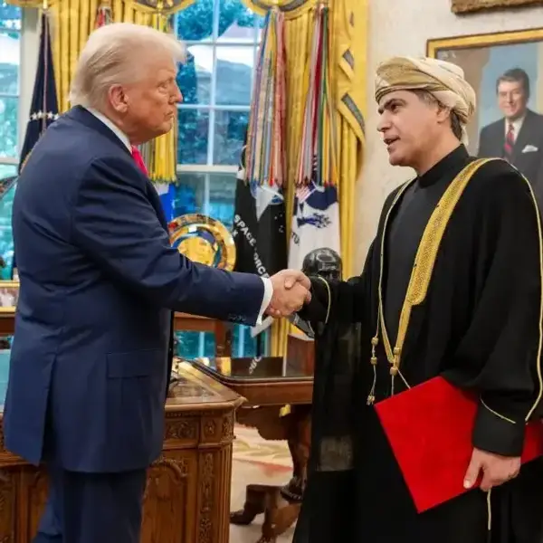 US President Donald Trump shakes hands with Omani Ambassador Talal Alrahbi